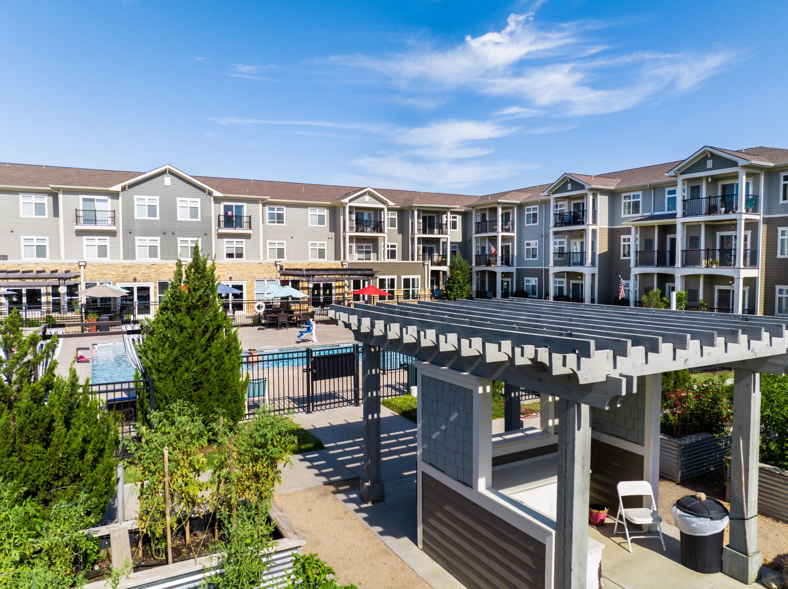 The Cedars courtyard with a pergola, pool and landscaped gardens