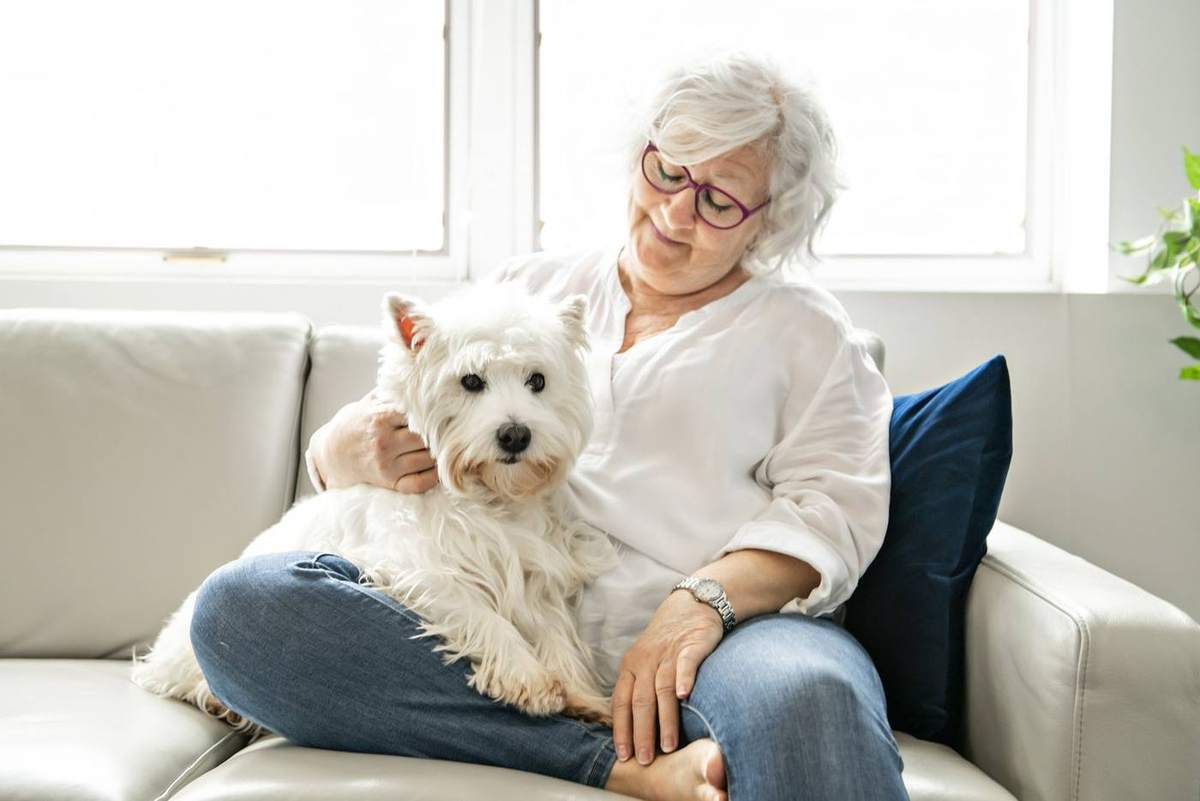 A resident relaxing at home with her small dog