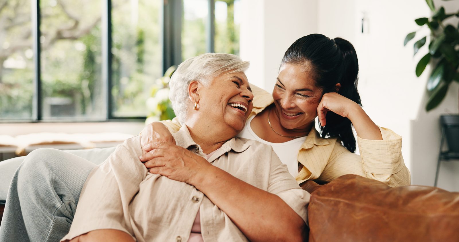 A resident laughing with her daughter on the sofa