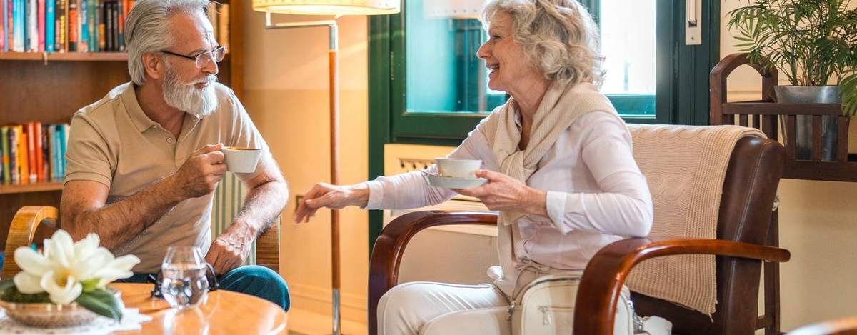 Two residents chatting over coffee in the library