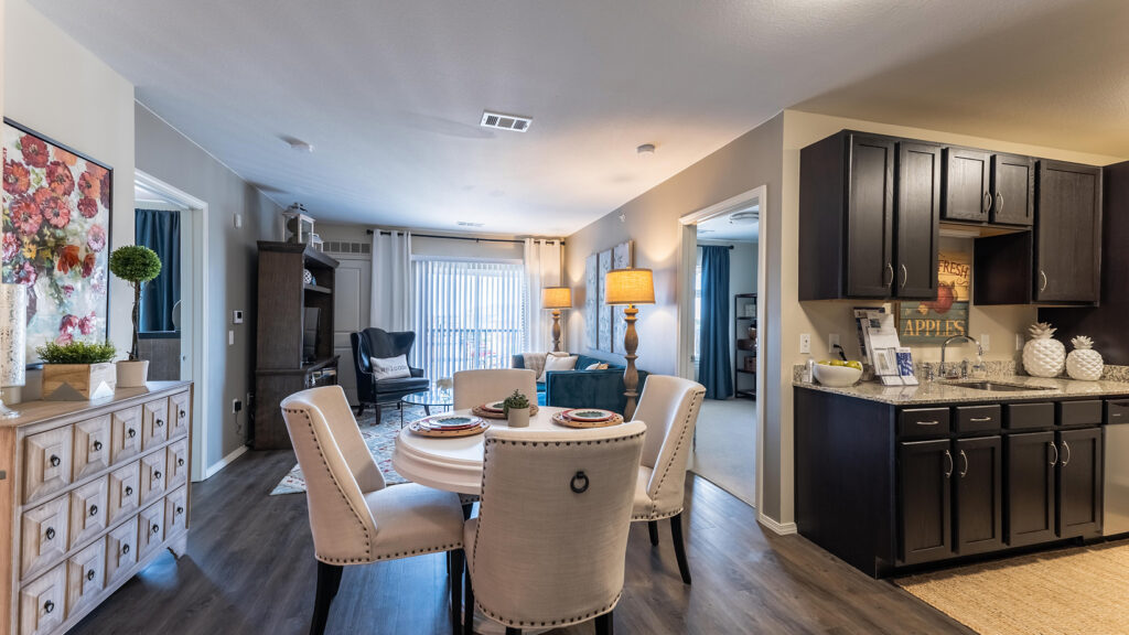 Apartment living area with a round dining table and dark kitchen cabinets